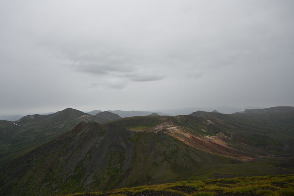 旭岳山頂から望む北鎮岳（左側の三角形の高い山）方面。学生時代に登った赤岳は、はっきりしませんが、写真の右端のほうです。