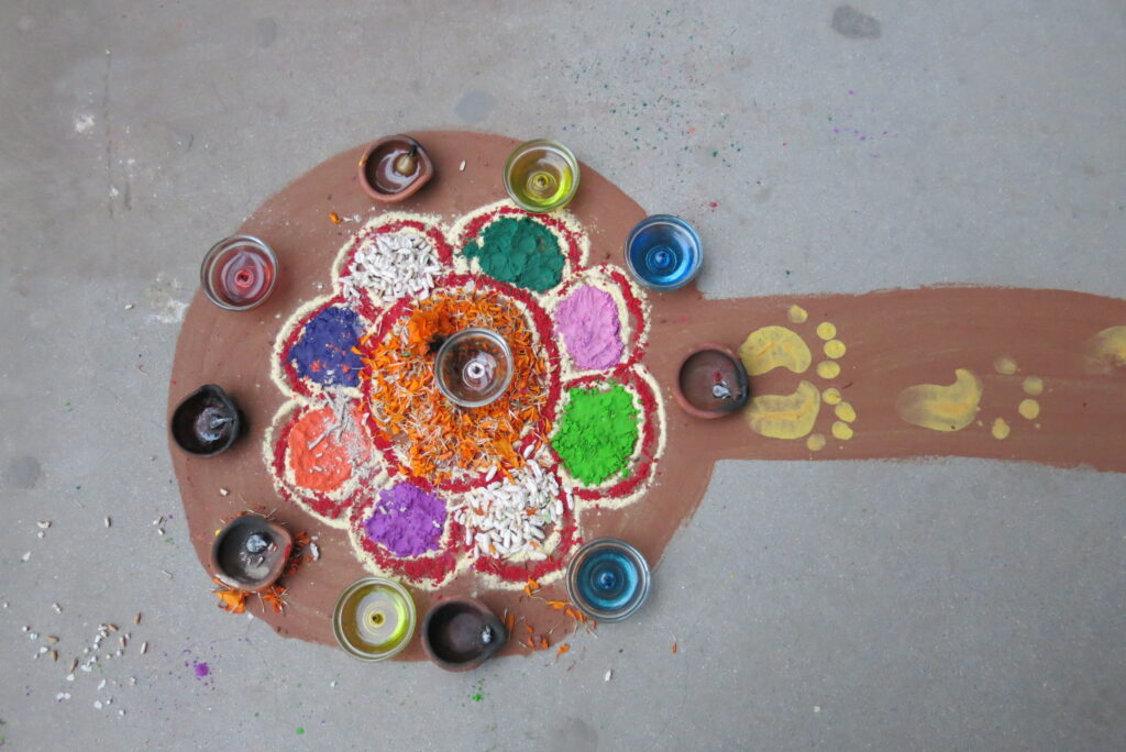 カトマンドゥの家の前の地面に描かれたティハール宗教的な飾り。富の女神ラクシュミーを家に誘う、色粉の飾り絵が玄関前や店先に描かれる。